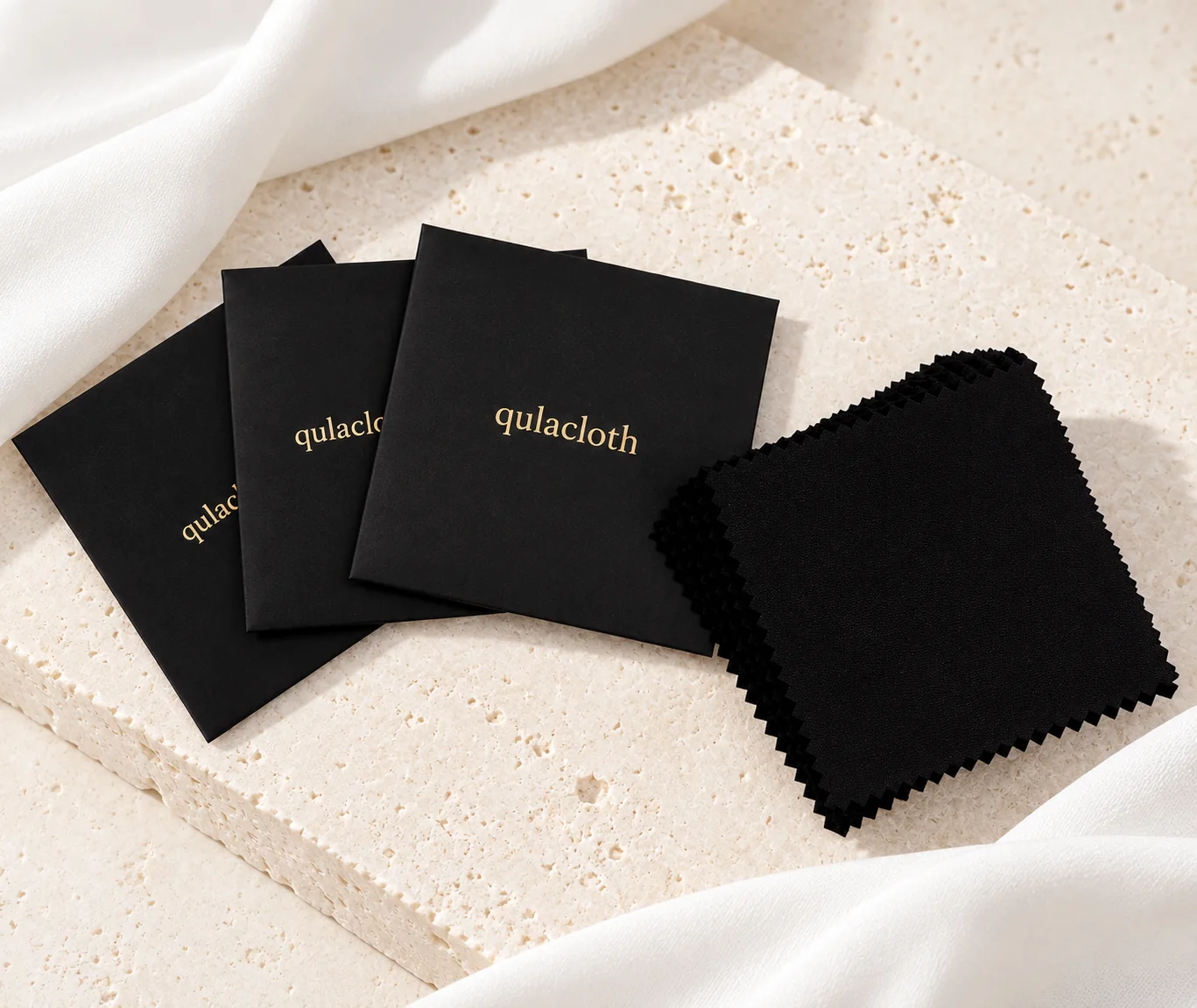 Black 8 x 8 cm jewelry cleaning cloths with black paper envelopes and gold Qulacloth logos