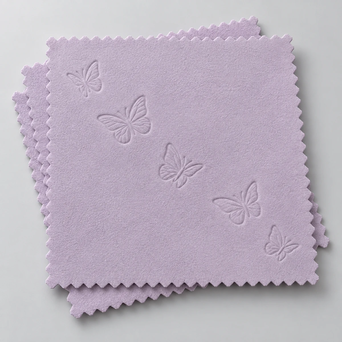 Lilac silver polishing cloths with embossed butterfly motifs and zigzag edges