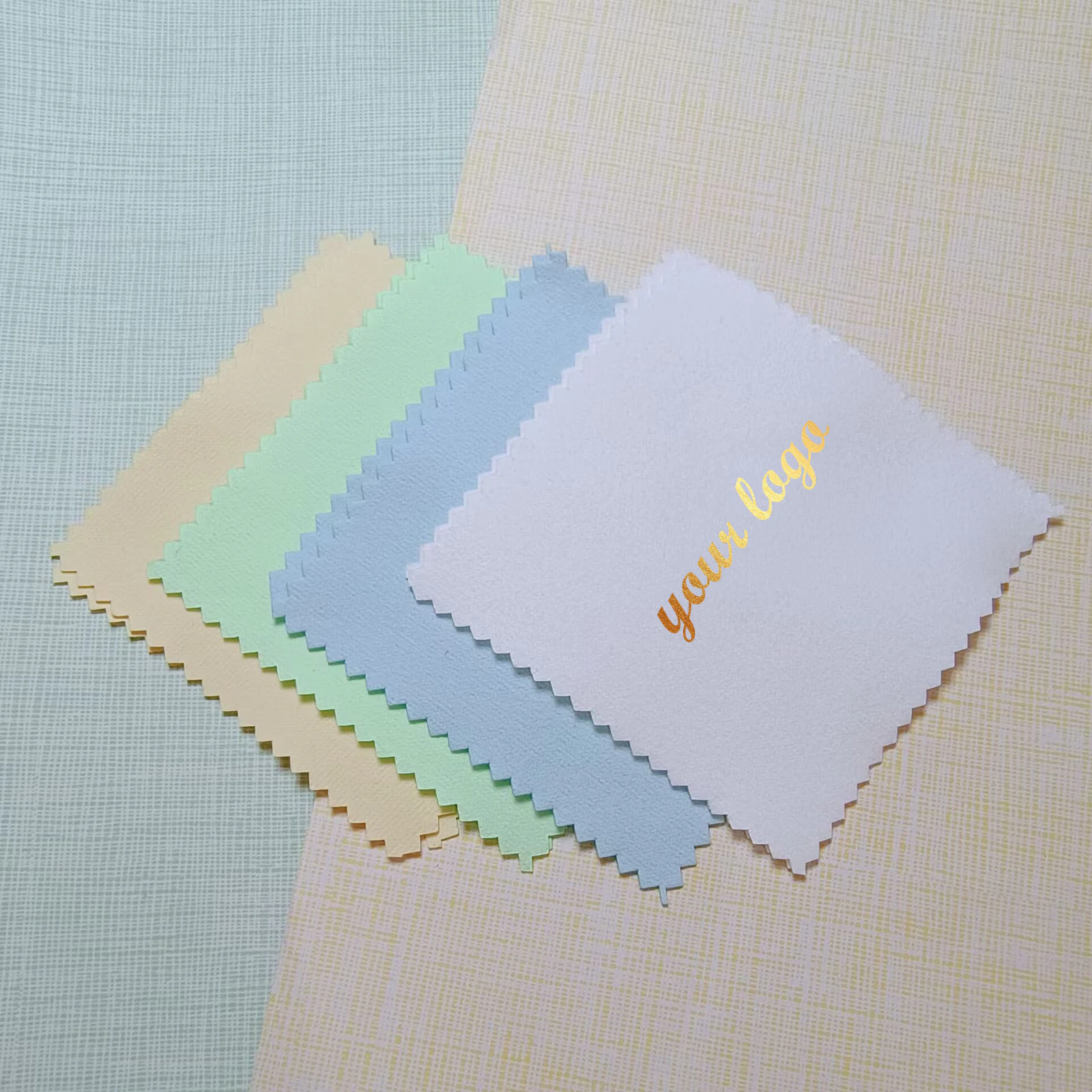 Pastel jewelry polishing cloths with a metallic gold custom logo on the front lavender cloth