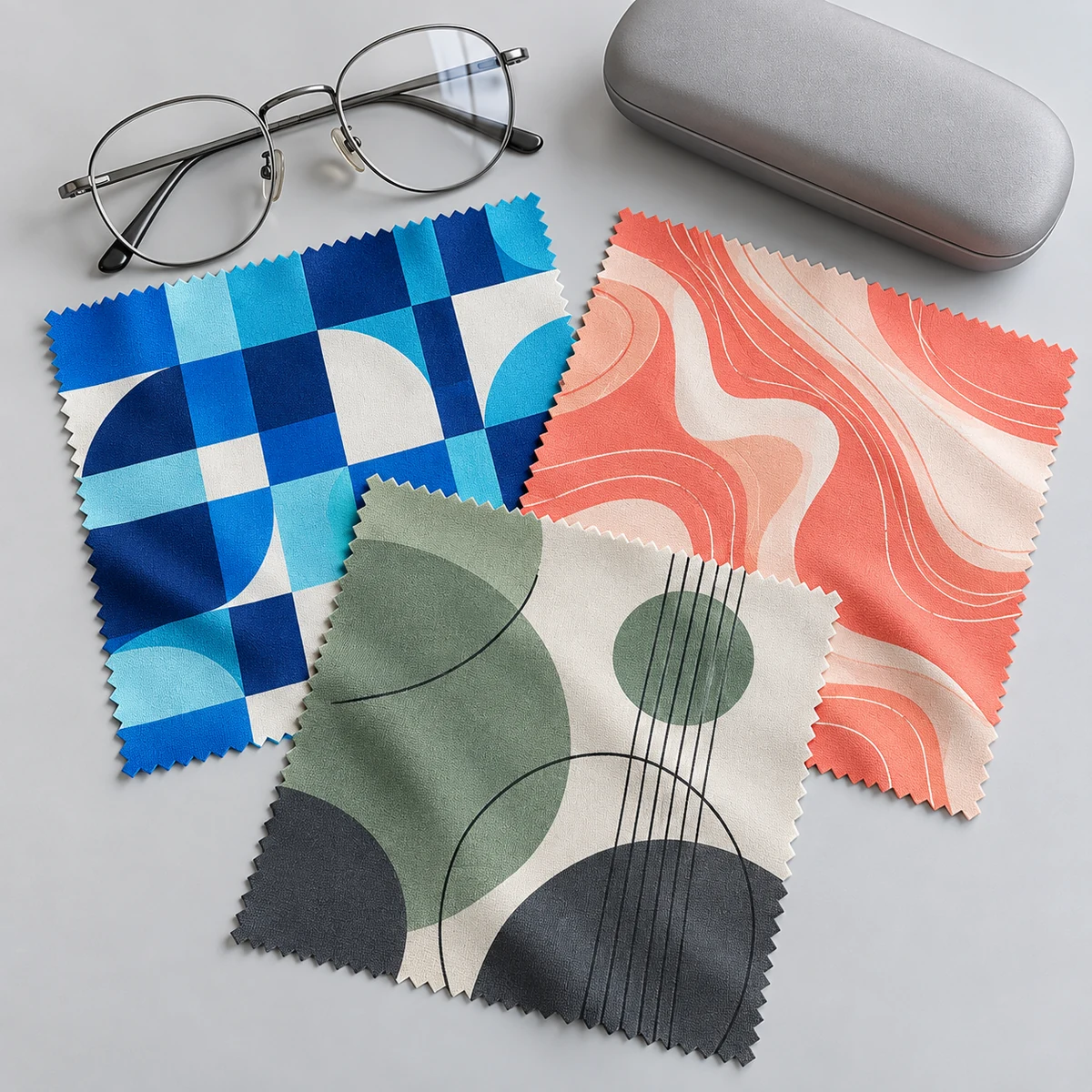 Three custom full-print 10 x 10 cm microfiber eyeglass cloths with original geometric patterns