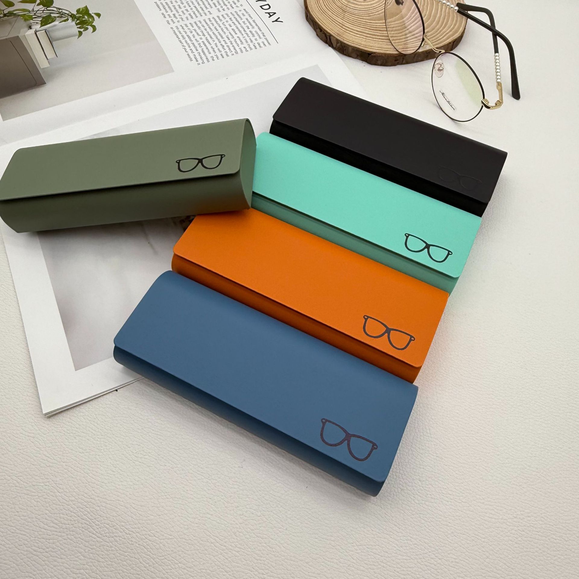Green, black, mint, orange and blue eyeglass cases with flap closures