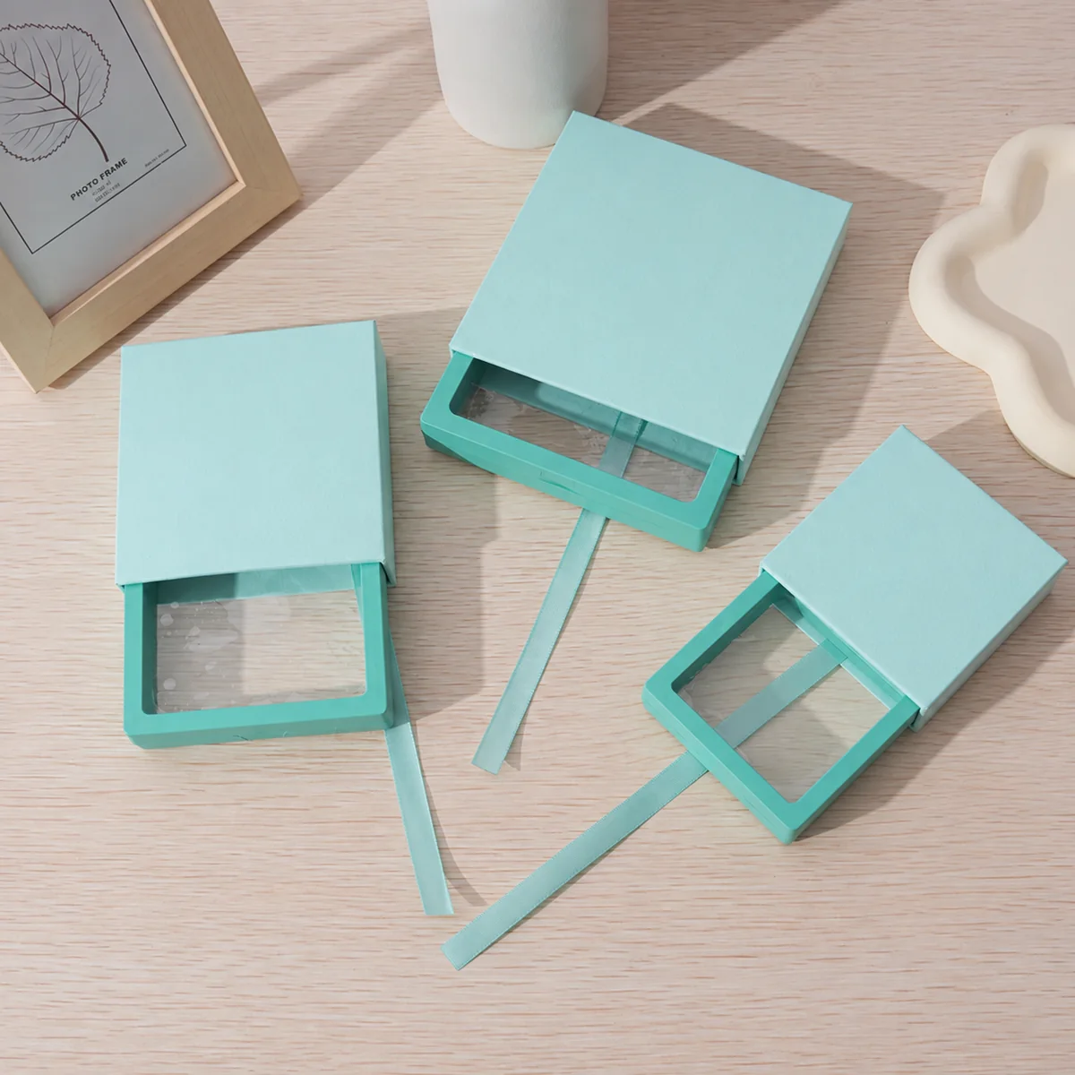 Three mint green drawer jewelry boxes with clear PE film windows and matching ribbon pulls