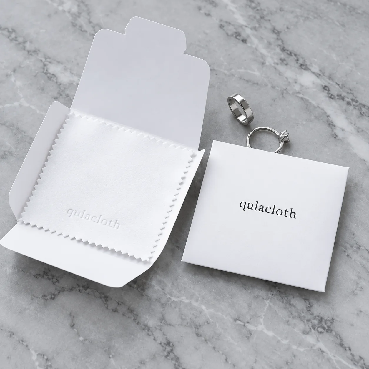 White 8 x 8 cm jewelry polishing cloth with Qulacloth paper envelope and two silver rings