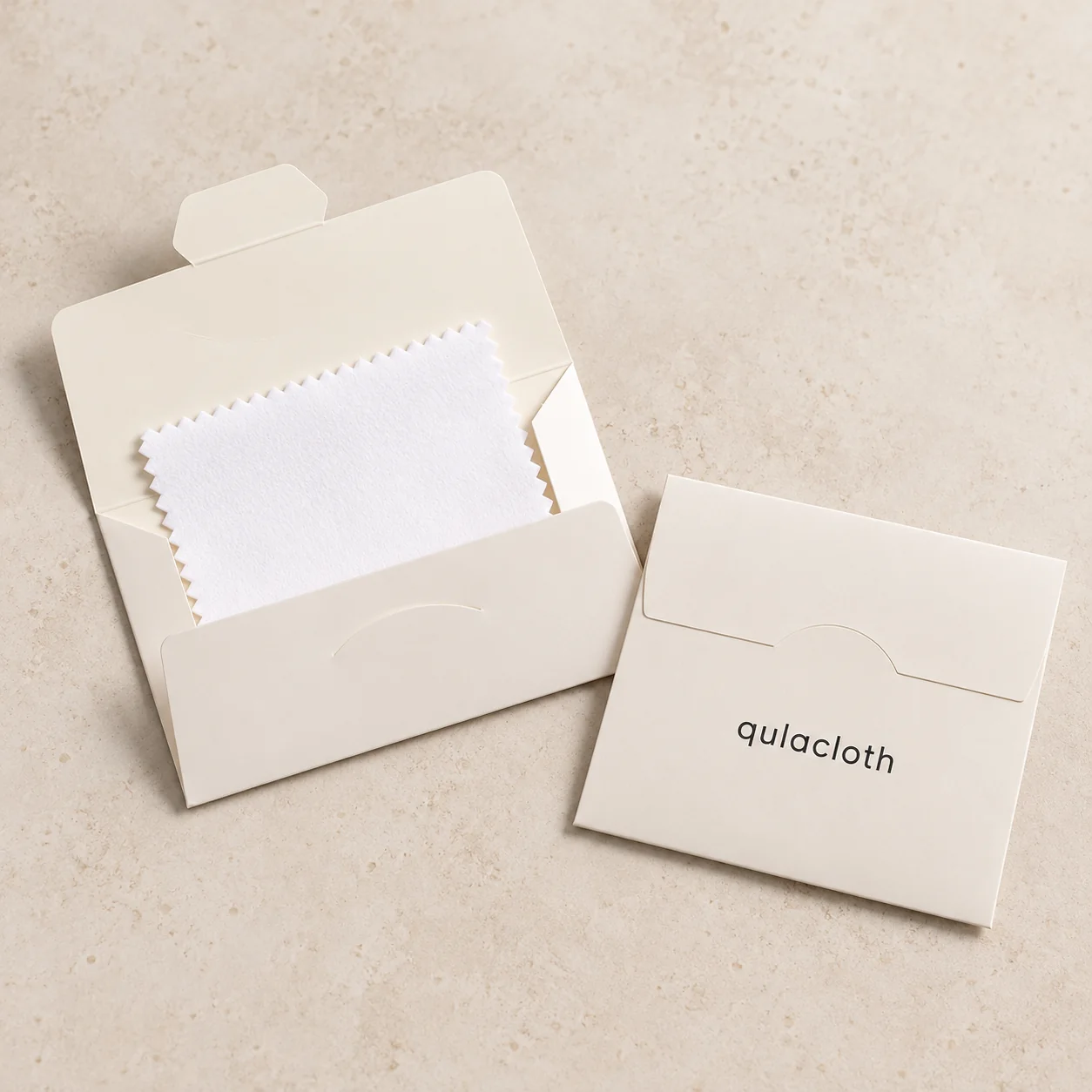 White 8 x 8 cm jewelry polishing cloth in a folding paper envelope with Qulacloth logo