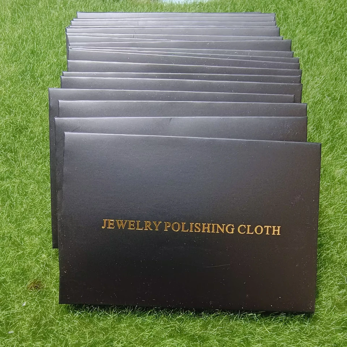 Wholesale stack of black paper envelopes with gold foil Jewelry Polishing Cloth lettering
